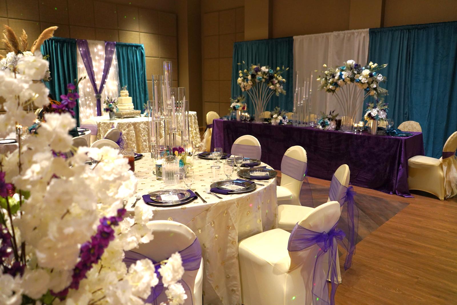 An event space with wedding decorations and a round table with banquet place settings
