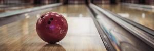 A forced perspective image of a bowling lane with a ball in the foreground